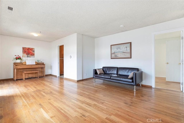 living room featuring a textured ceiling and light wood-type flooring