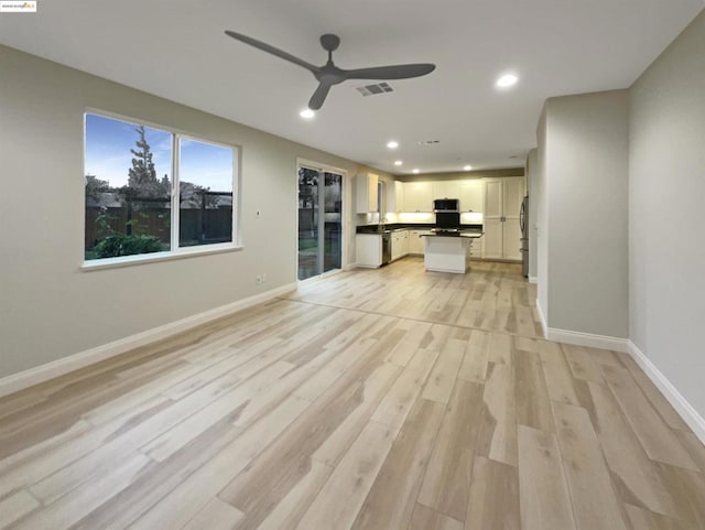 unfurnished living room with ceiling fan and light hardwood / wood-style flooring