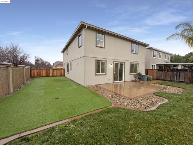 rear view of house with central AC unit, a patio area, and a yard