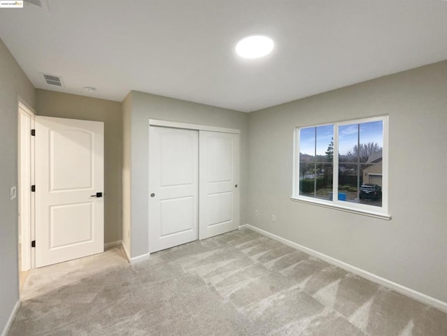 unfurnished bedroom featuring a closet and light carpet