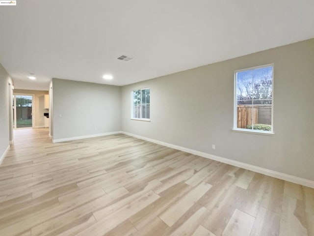 spare room with a wealth of natural light and light hardwood / wood-style floors