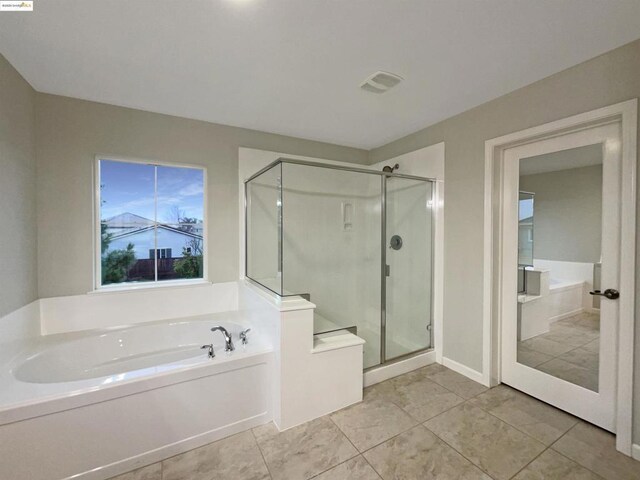 bathroom featuring plus walk in shower and tile patterned flooring