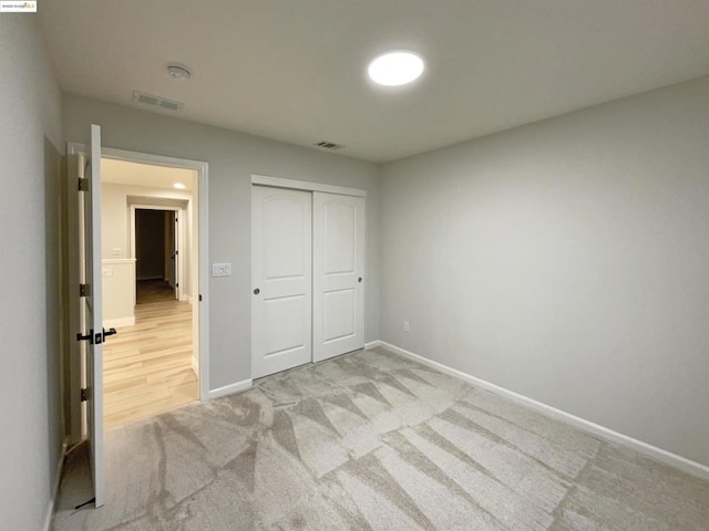 unfurnished bedroom featuring a closet and light carpet