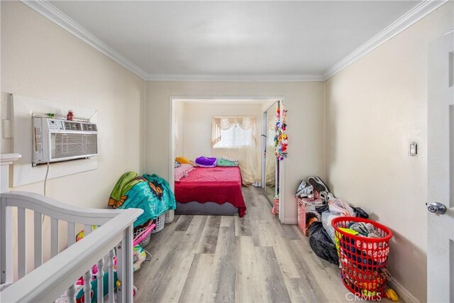 bedroom with light wood-type flooring, crown molding, and cooling unit