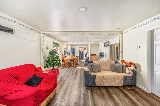 living room featuring wood-type flooring and crown molding