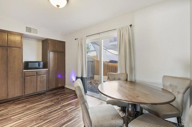 dining space with dark hardwood / wood-style flooring