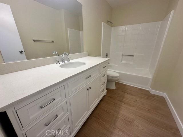 full bathroom with hardwood / wood-style flooring, toilet, vanity, and shower / washtub combination