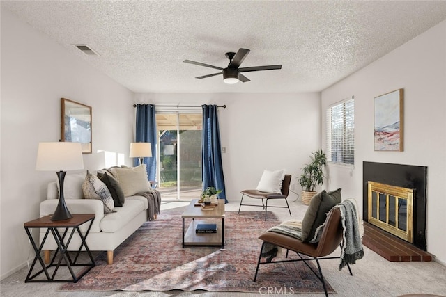 carpeted living room with a textured ceiling and ceiling fan