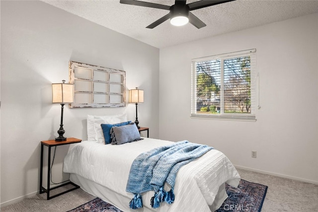 bedroom with ceiling fan, light colored carpet, and a textured ceiling