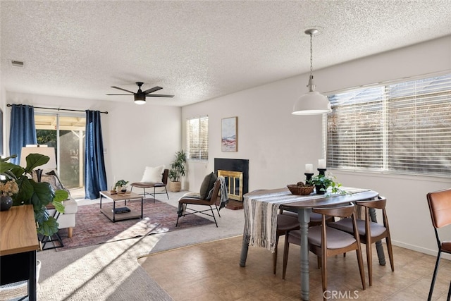 dining area featuring ceiling fan, a textured ceiling, and a wealth of natural light