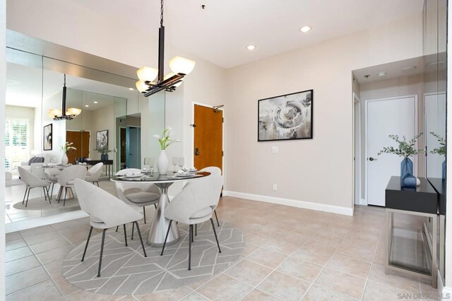 dining room with light tile patterned floors and a notable chandelier