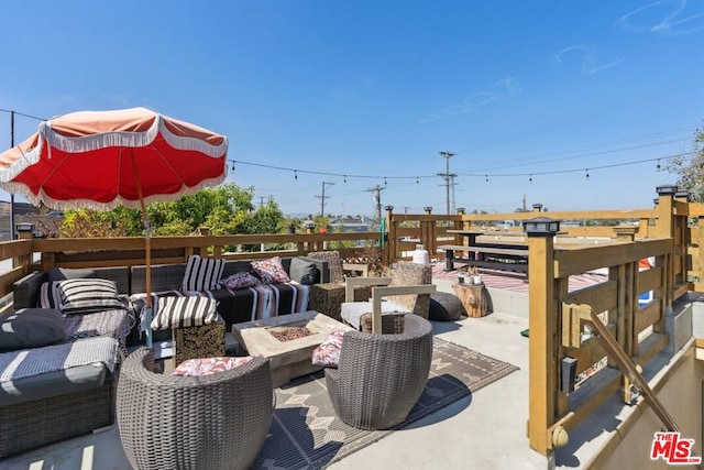 view of patio with an outdoor living space with a fire pit