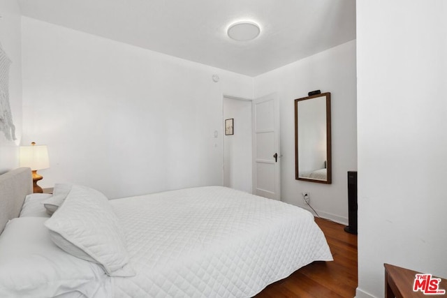 bedroom with dark wood-type flooring