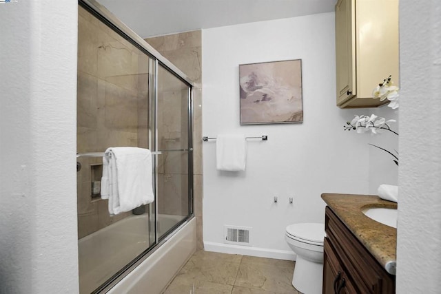 full bathroom with toilet, tile patterned floors, vanity, and enclosed tub / shower combo