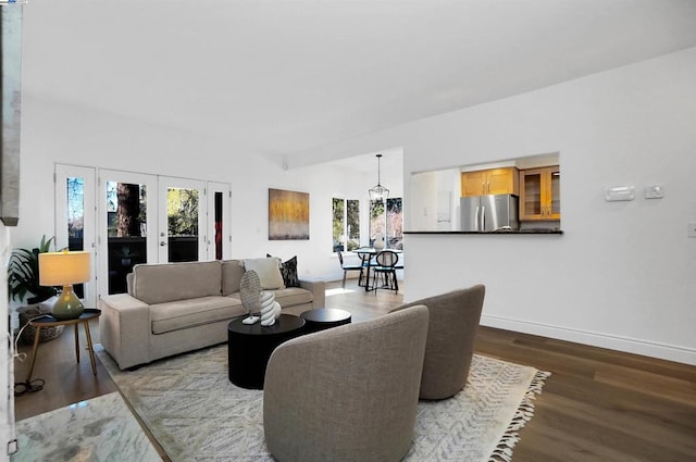 living room featuring wood-type flooring, a chandelier, and french doors