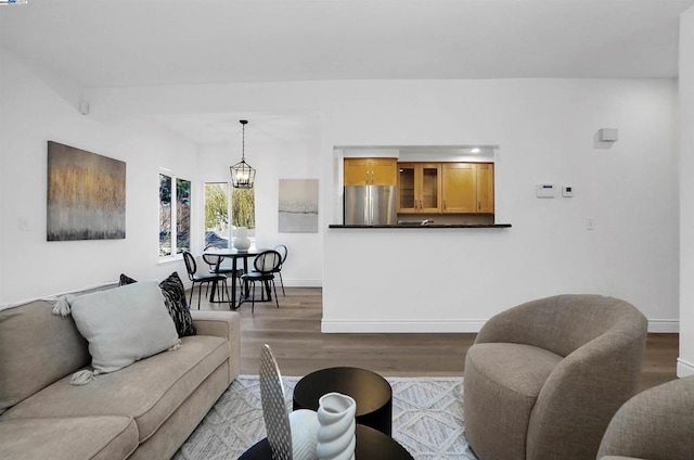 living room with hardwood / wood-style floors and an inviting chandelier