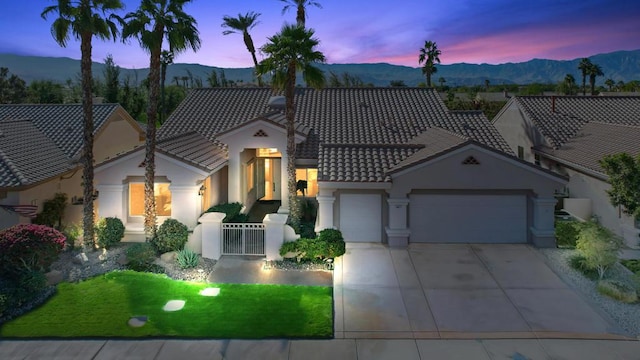 view of front of house featuring a lawn, a mountain view, and a garage