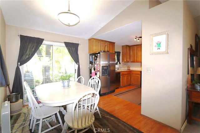 dining area featuring hardwood / wood-style flooring and vaulted ceiling