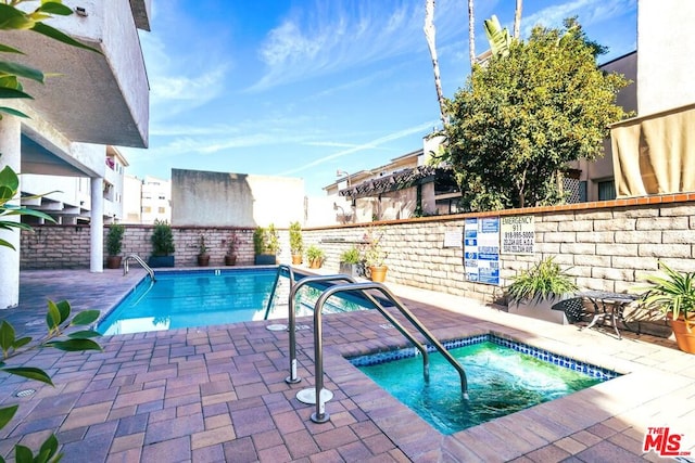 view of pool featuring a hot tub and a patio