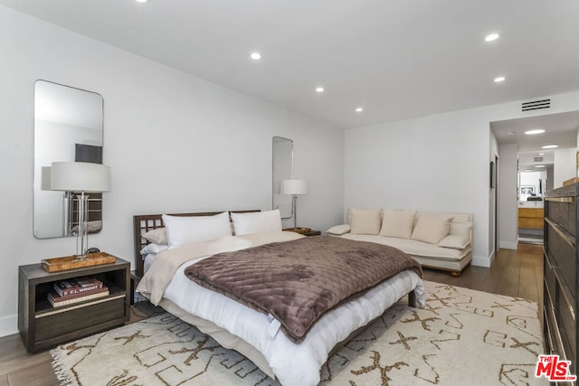 bedroom featuring hardwood / wood-style flooring and ensuite bath