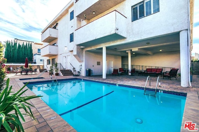 view of pool featuring an outdoor hangout area, cooling unit, and a patio