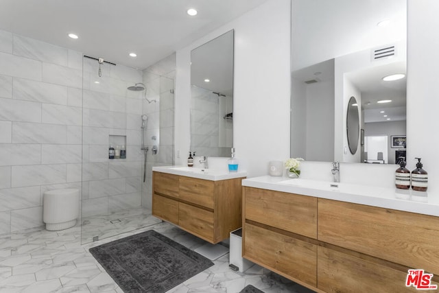 bathroom with tiled shower and vanity