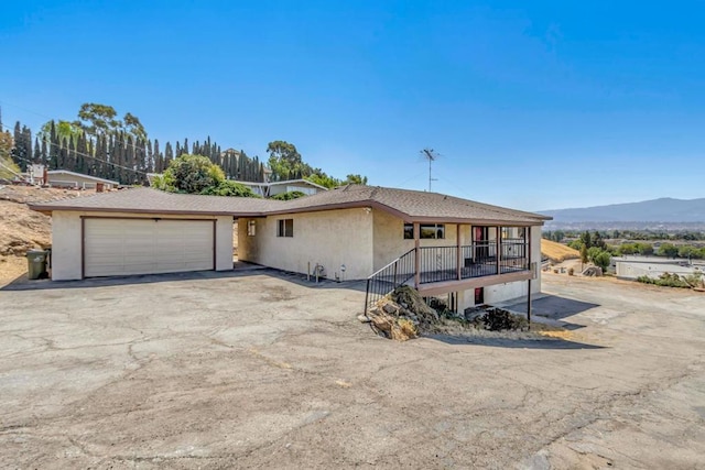 view of front facade with a mountain view, covered porch, and a garage