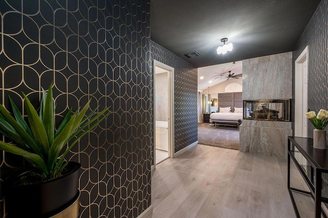 hallway featuring light hardwood / wood-style flooring and lofted ceiling