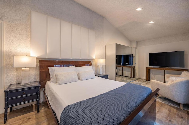 bedroom with light hardwood / wood-style floors and vaulted ceiling