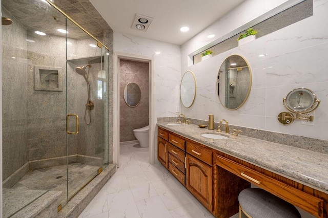 bathroom with toilet, tile walls, a shower with door, and vanity