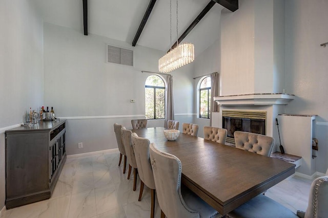 dining area with a chandelier, beam ceiling, and high vaulted ceiling