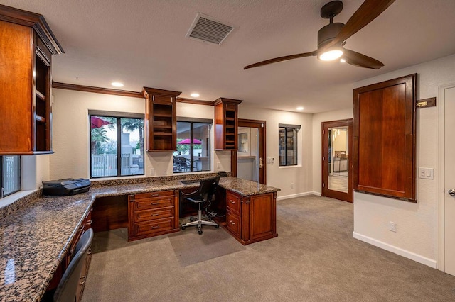 office featuring built in desk, light colored carpet, ceiling fan, and crown molding