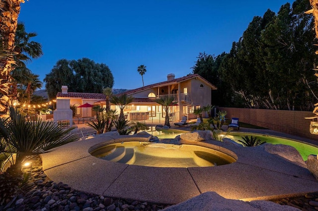 exterior space featuring a balcony, an in ground hot tub, and a patio