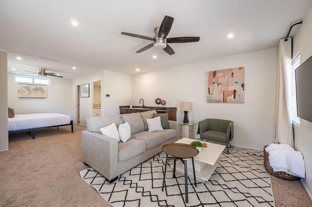 living room with ceiling fan, light colored carpet, and a healthy amount of sunlight