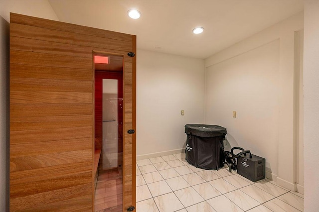 clothes washing area with light tile patterned floors