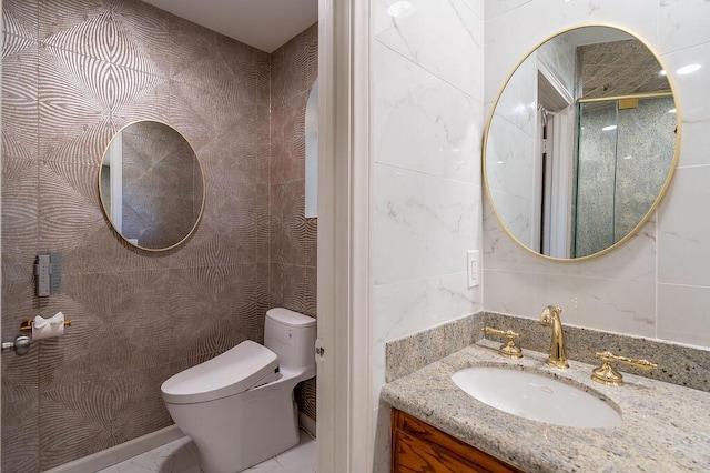 bathroom featuring toilet, vanity, and tile walls