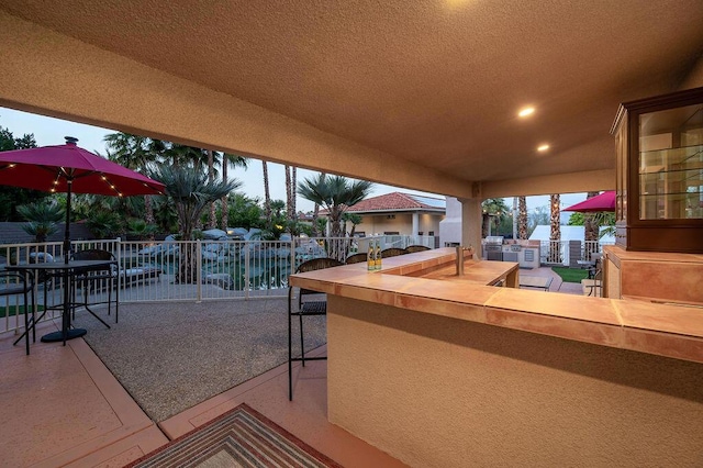 view of patio with an outdoor bar and a water view