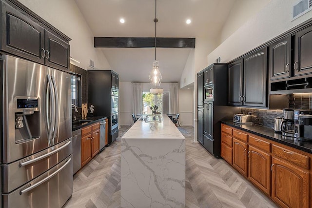 kitchen with decorative light fixtures, a kitchen island, beamed ceiling, light parquet floors, and stainless steel appliances