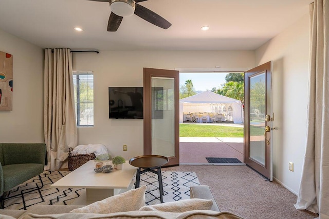 carpeted living room featuring ceiling fan