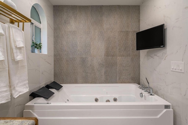 bathroom with tile walls and a tub