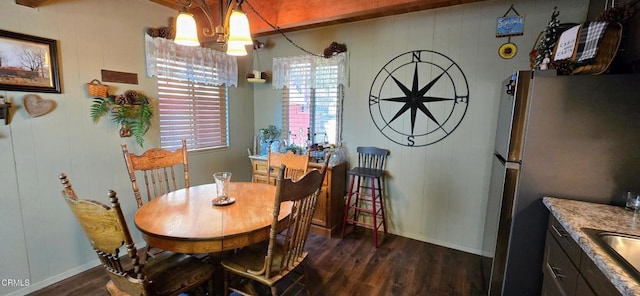 dining space with dark wood-type flooring and a chandelier