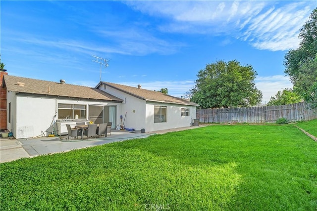 rear view of house with a patio and a yard