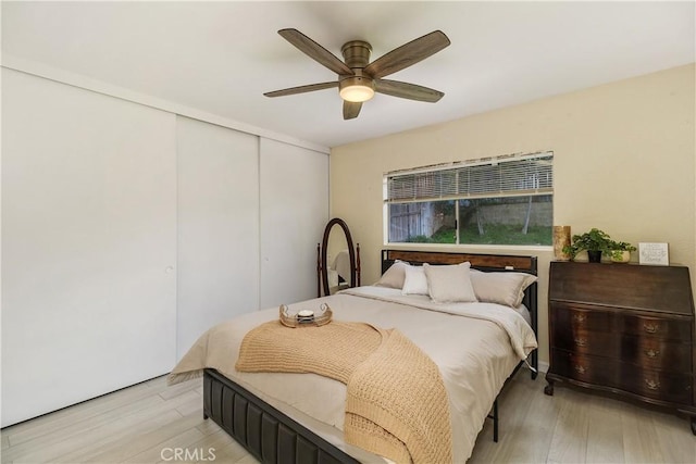 bedroom with ceiling fan, a closet, and light wood-type flooring