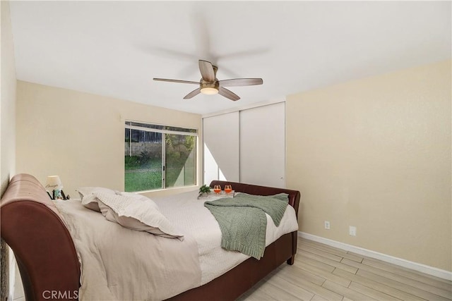 bedroom featuring ceiling fan, a closet, and light wood-type flooring