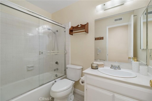 full bathroom featuring toilet, vanity, and shower / bath combination with glass door