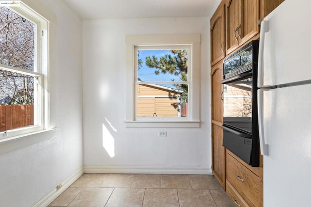 doorway with a healthy amount of sunlight and light tile patterned floors