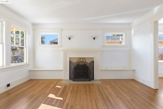 unfurnished living room featuring light wood-type flooring and a fireplace