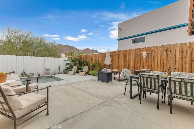 view of patio / terrace with an outdoor living space with a fire pit, a mountain view, and a fenced in pool