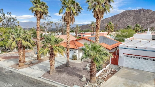 view of front of property with a mountain view and solar panels