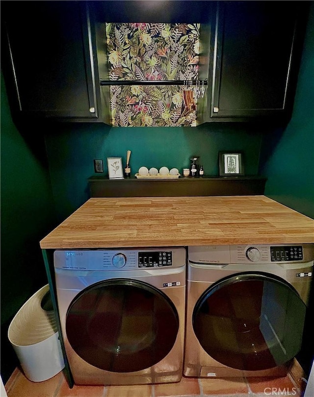 clothes washing area with washing machine and dryer and cabinets